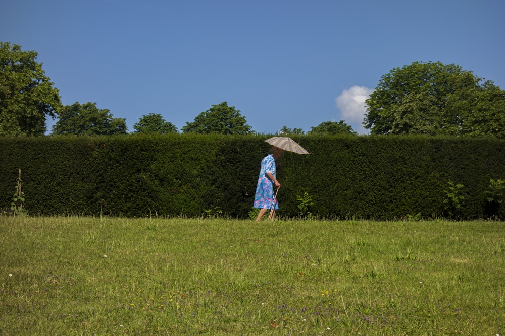 woman walking on grass field with bosh