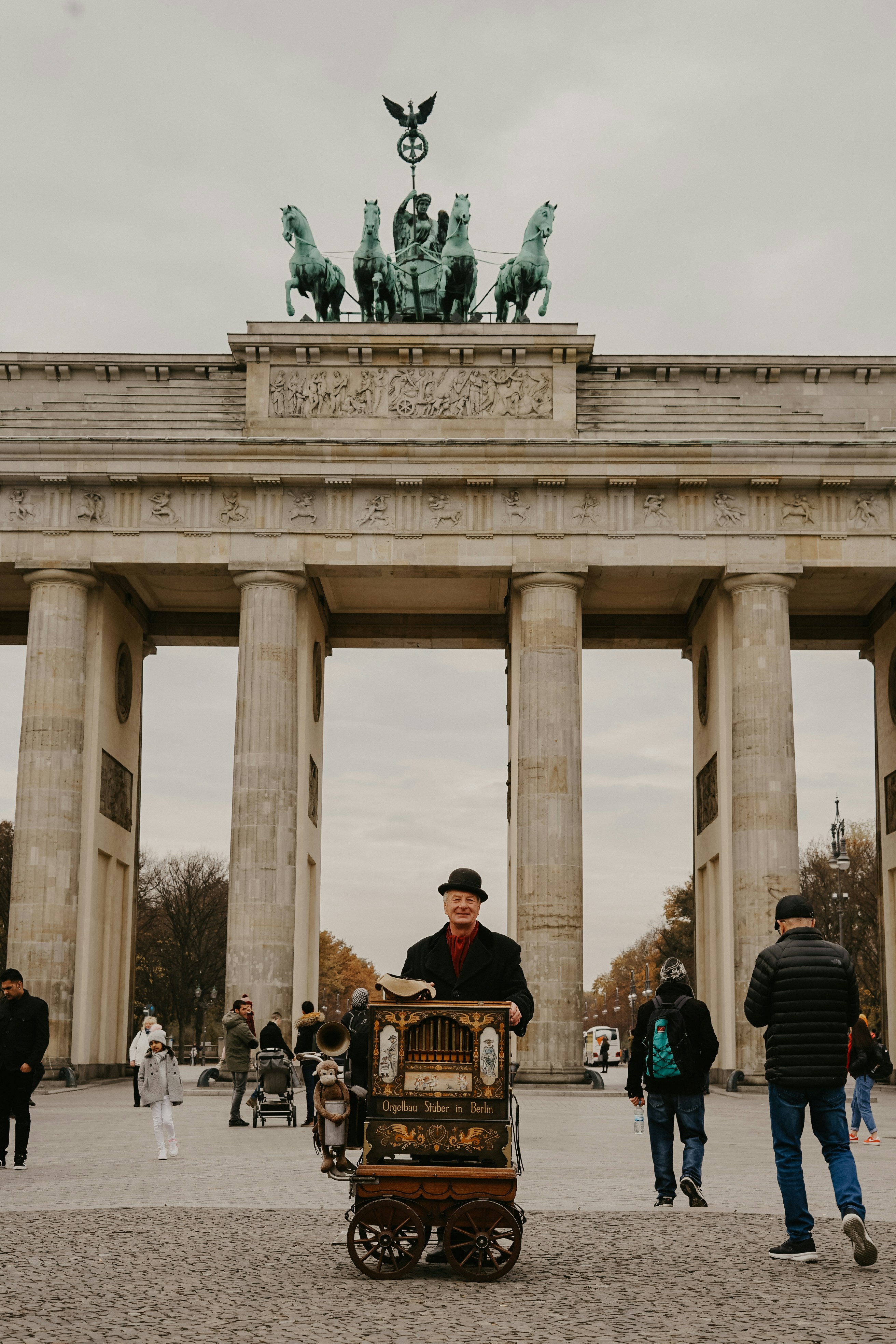 homem em pé atrás do carrinho em frente ao portão de Brandemburgo