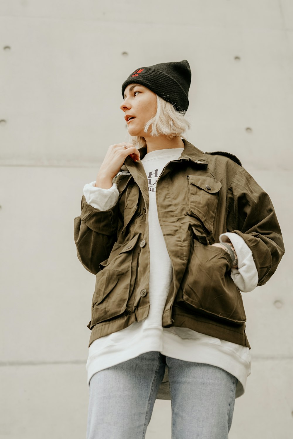 Femme en veste marron avec chemise intérieure blanche et jean en jean bleu