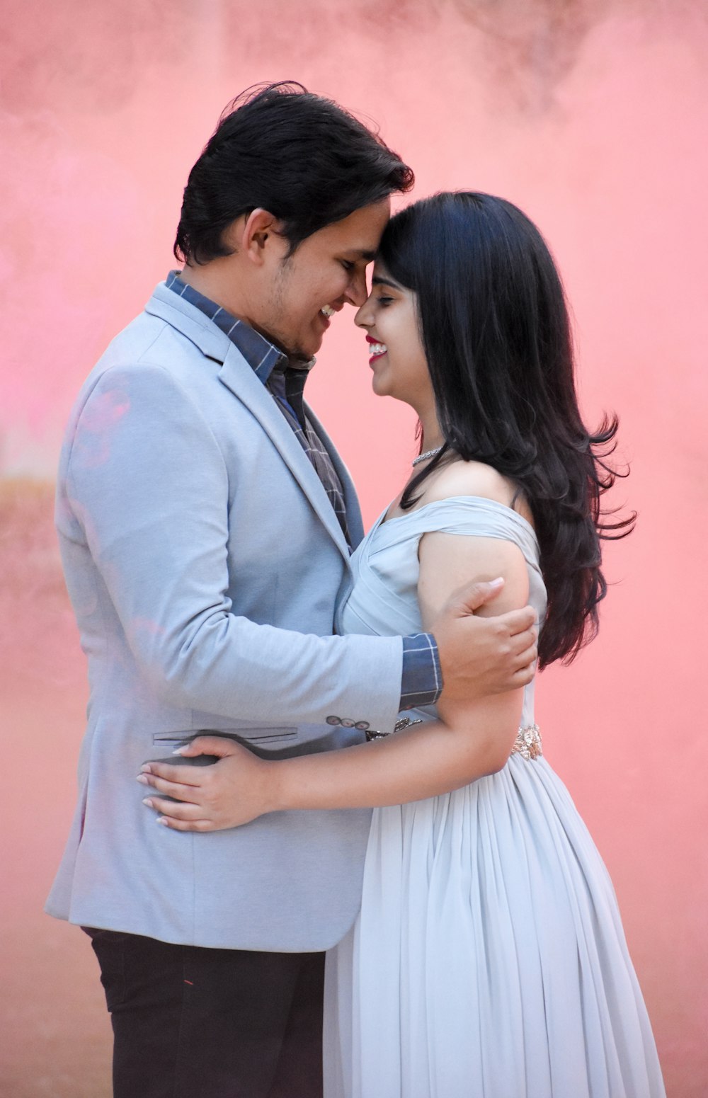 man in grey suit jacket and woman in white sleeveless dress