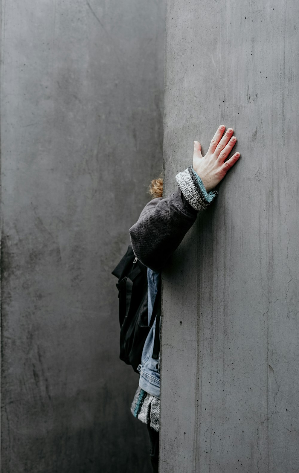 person touching gray wall