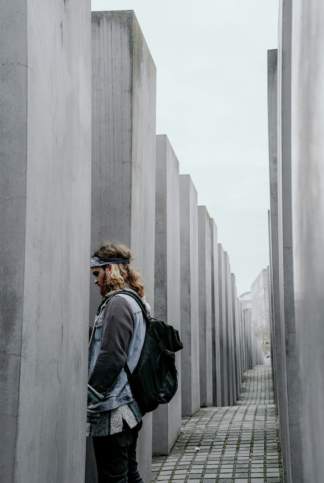 standing man in front of gray concrete wall