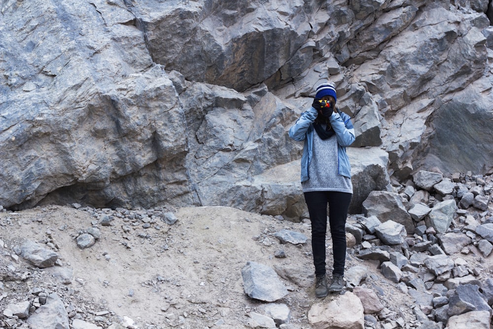 woman taking photo while standing on rock