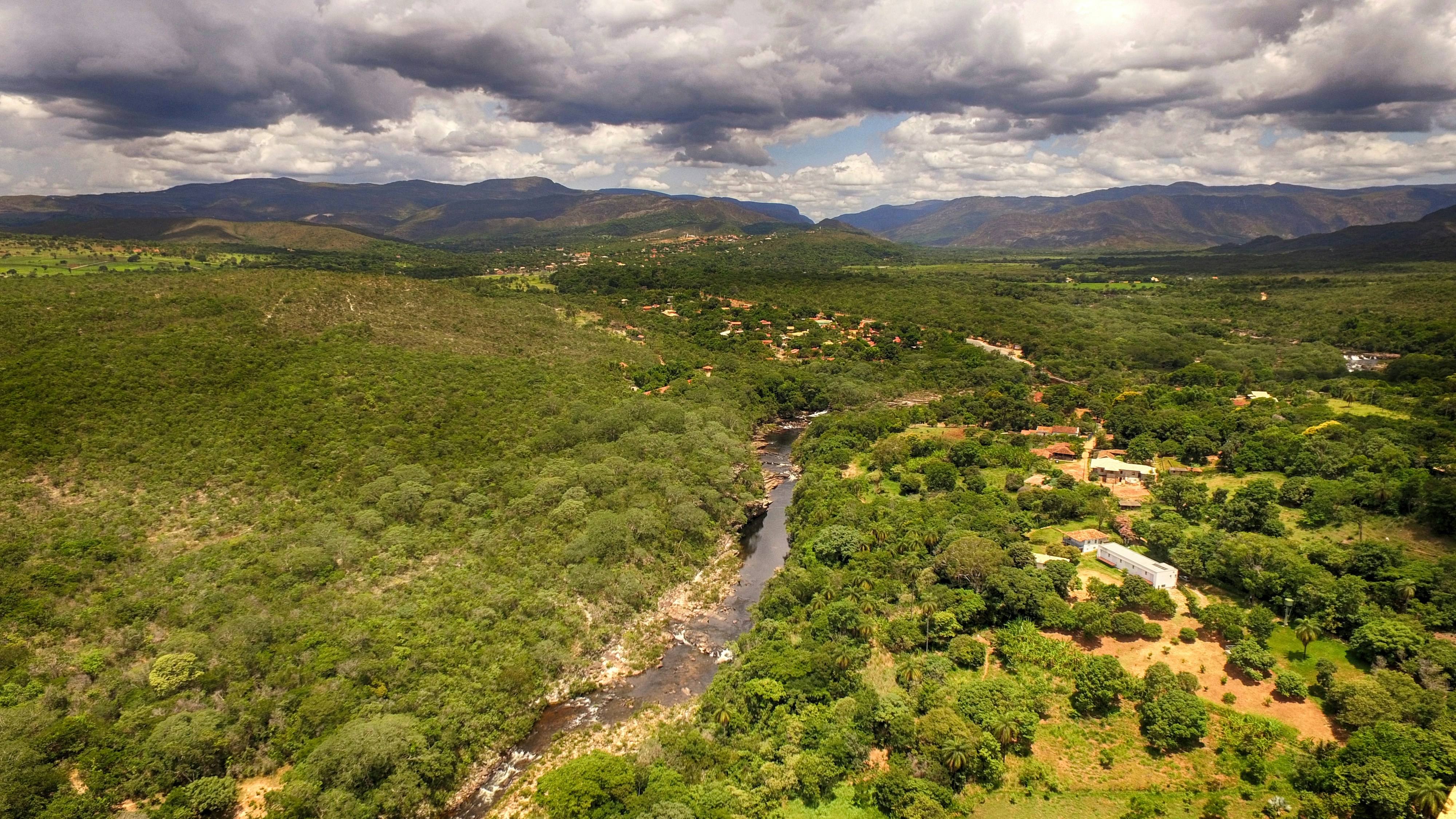 Aerial view of lush green valley with winding river in bright daylight
