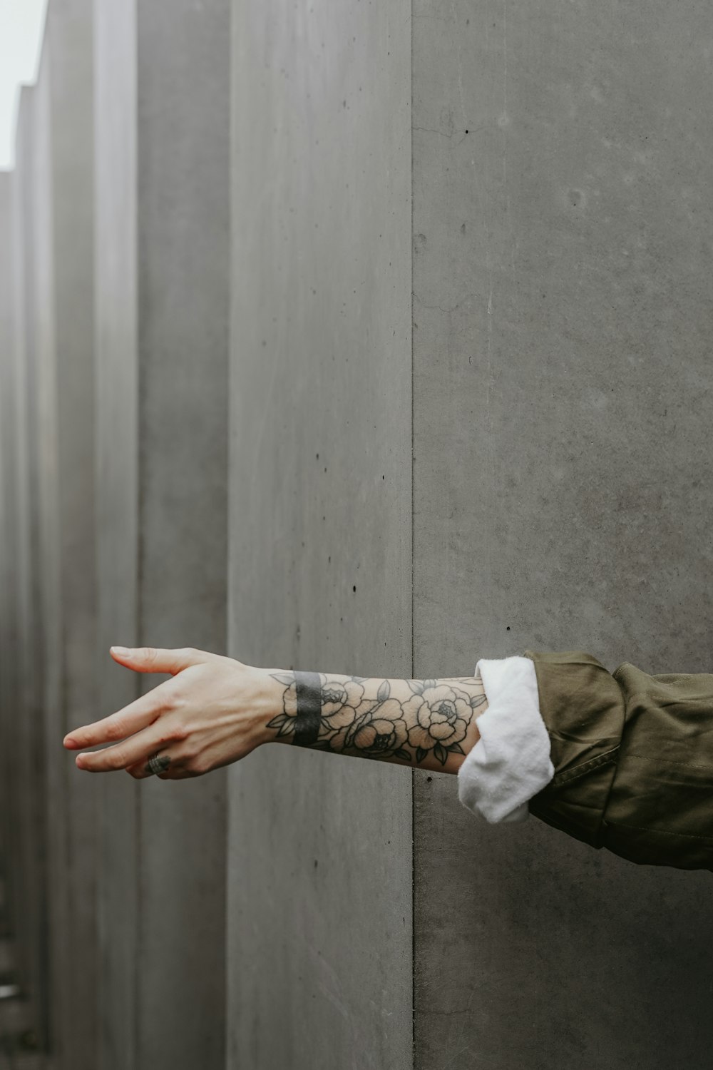 person in green long-sleeved shirt showing tattoo