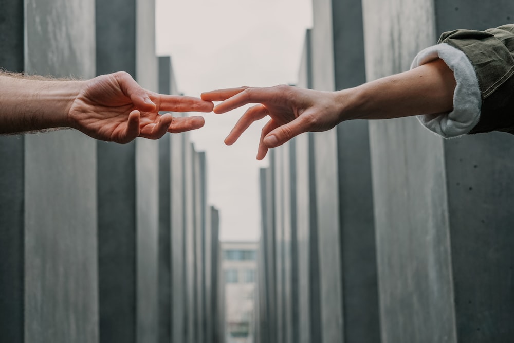 two person touching each others finger tips