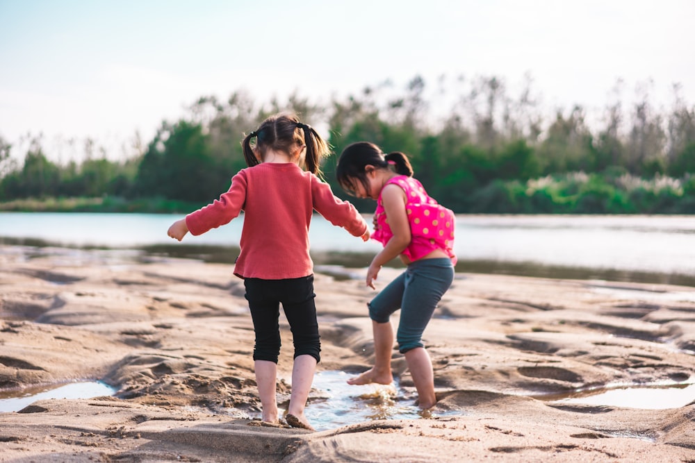 Photo de mise au point peu profonde de filles jouant dans le sable pendant la journée