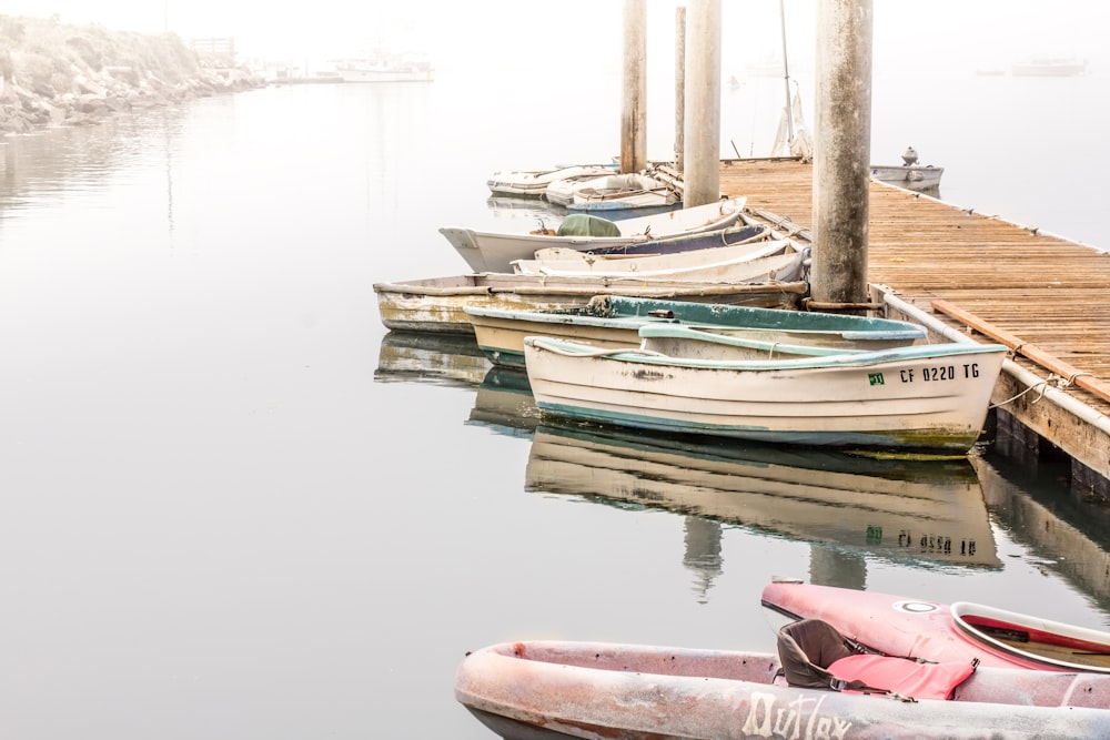 kayak and boats beside wooden dock