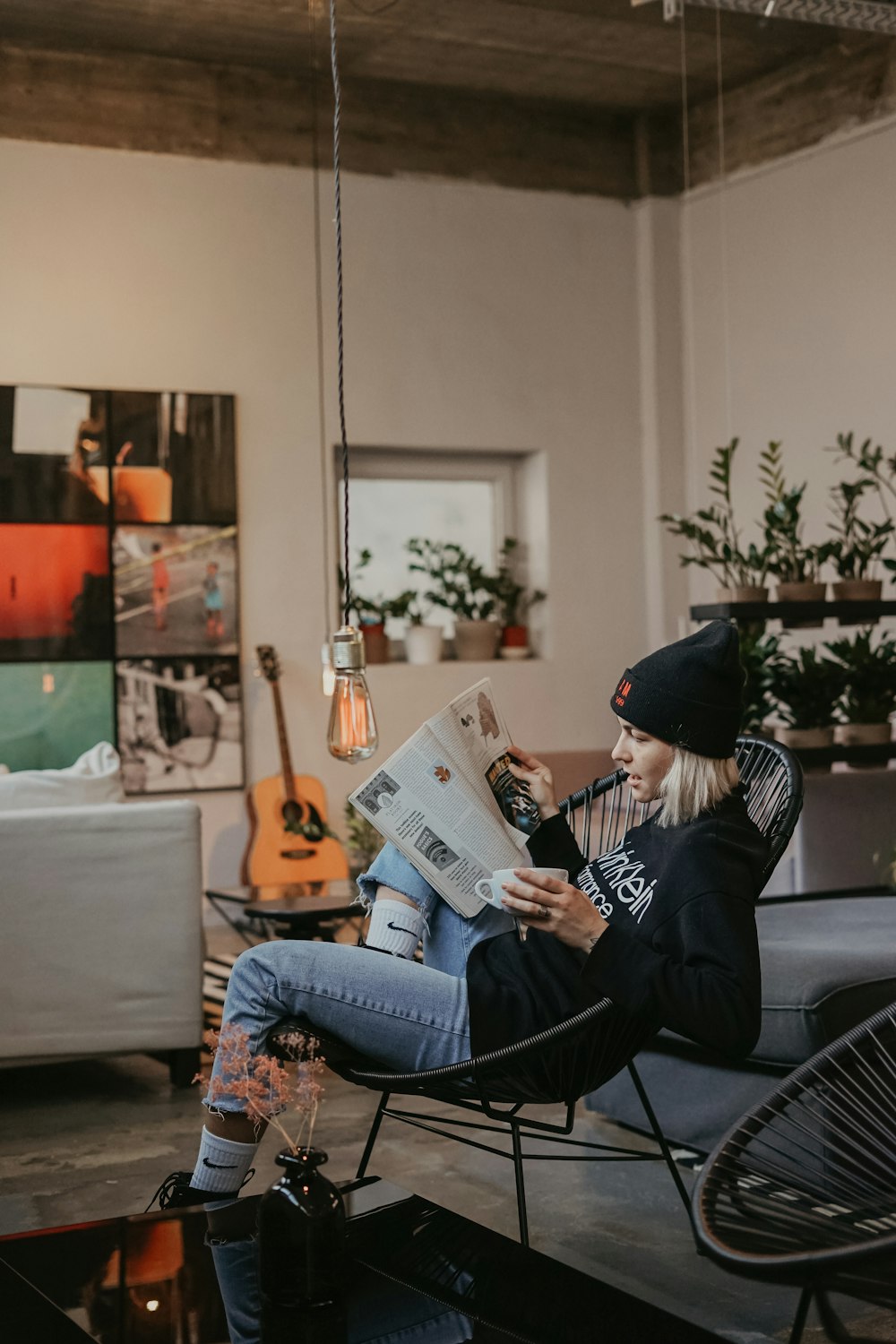 woman sitting on moon chair reading magazine