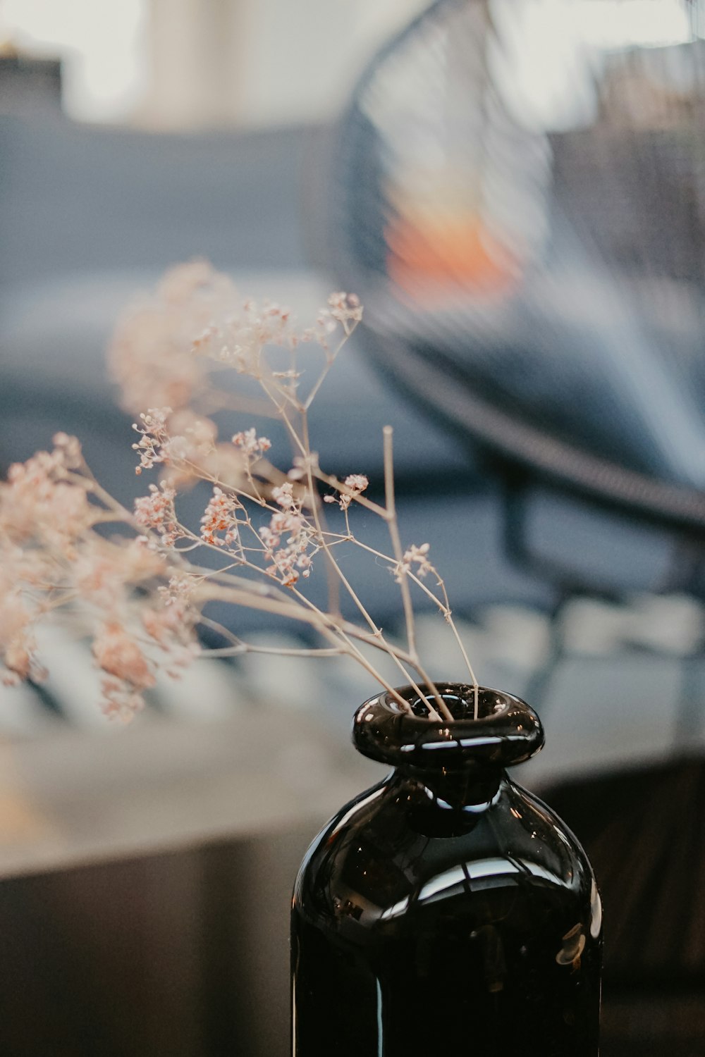 flowers in black glass bottle on table
