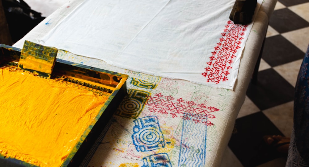 white textile beside paint bucket on table