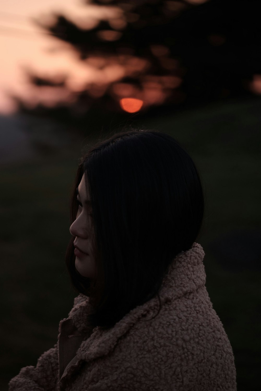 girl wearing brown jacket standing outdoor during golden hour