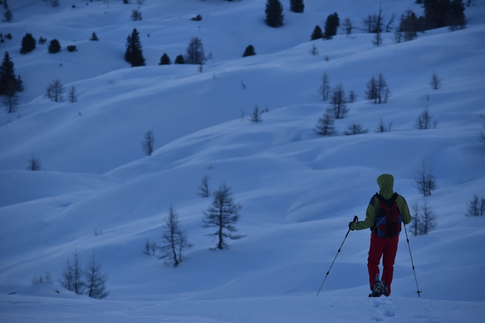 man walks with ski poles at snowfield