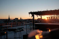 A serene hotel rooftop setting at dusk with a jazz trio performing against the city skyline.