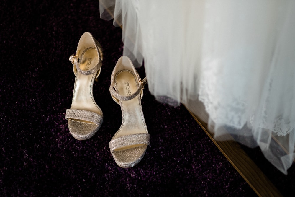 pair of gray and beige leather open-toe ankle-strap heels on the floor