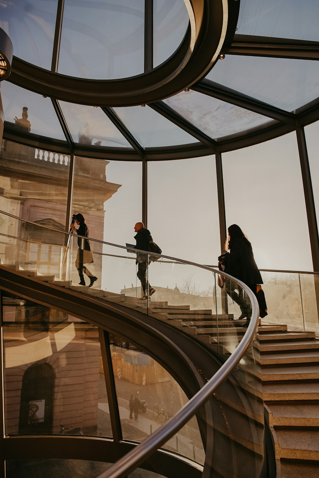 three women walking upstairs at the glass building