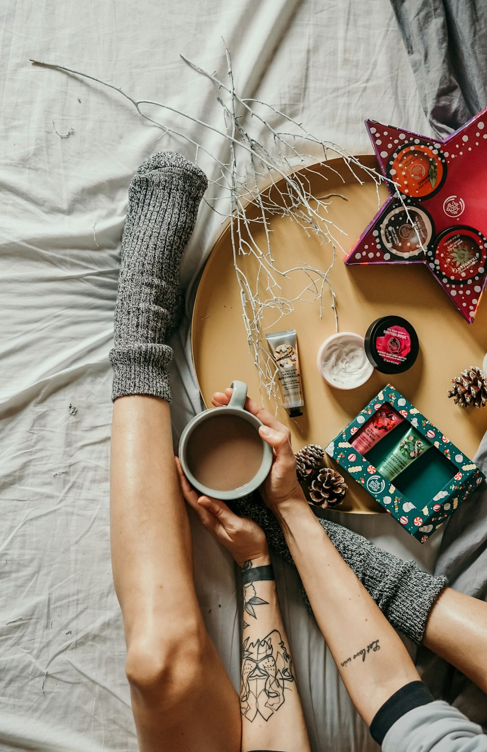 person holding cup of coffee while on bed