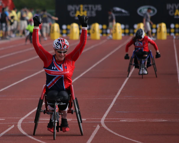 A group of para athletes celebrating a victory, smiles wide, with medals shining under bright stadium lights.