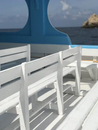 White and navy blue marine cushions arranged neatly on a boat deck under bright sunlight.