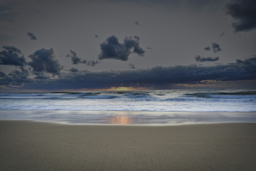 grey and blue clouds over beach at sunset