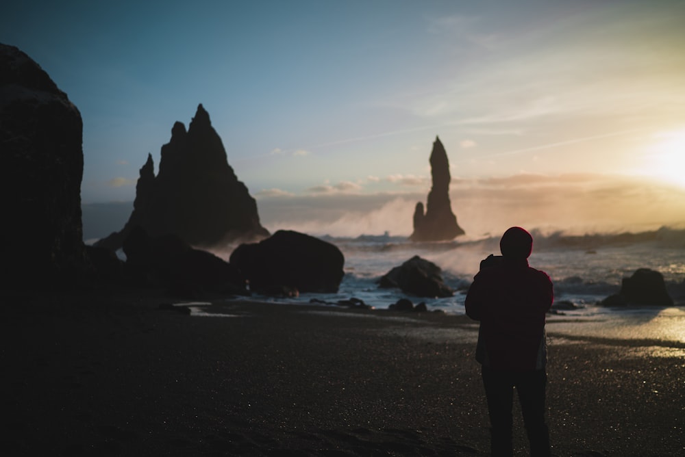 person standing in the beach during golden hour