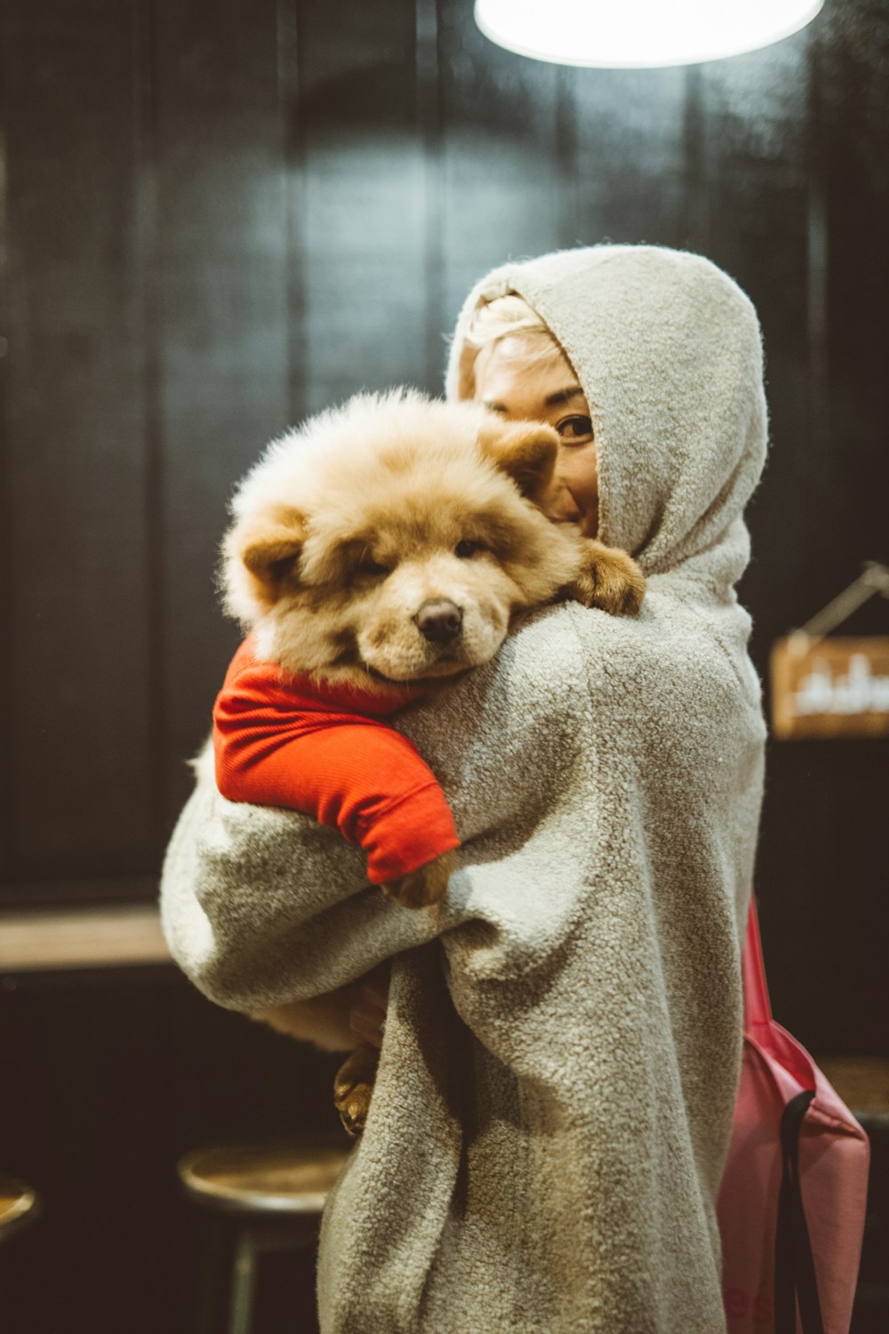 woman carrying beige dog