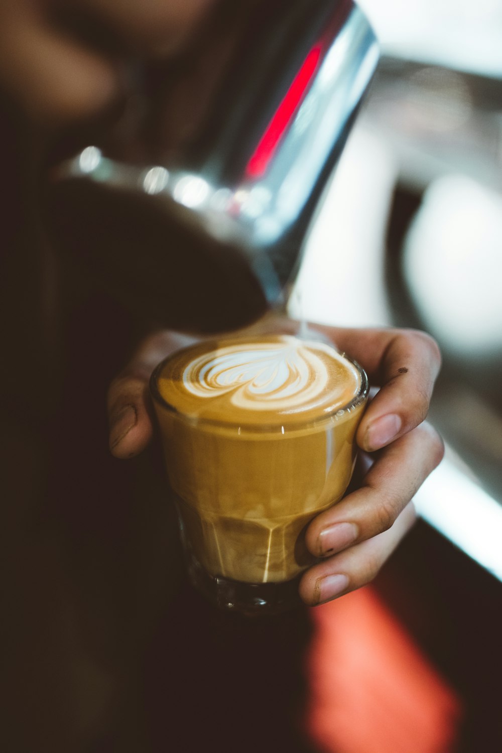 Persona sosteniendo un café con leche