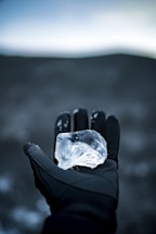 A friendly iceman handing a clear ice cube to a smiling event host in an elegant venue.