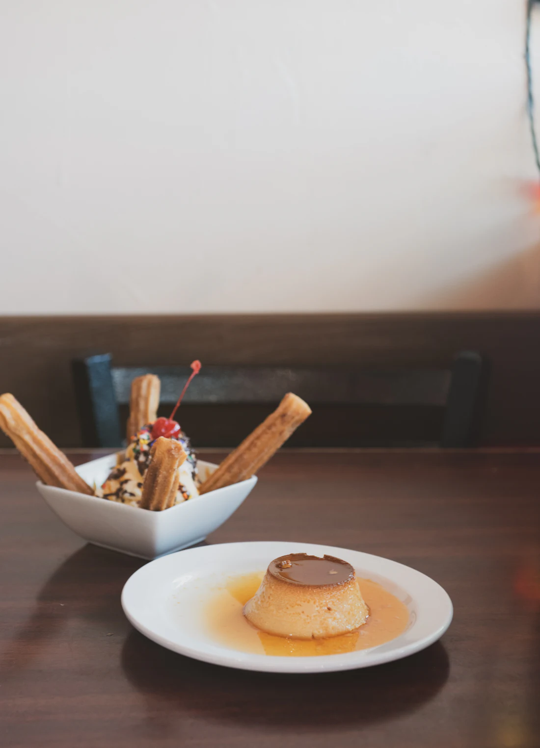 A round custard flan turned out onto a white plate with caramel running off it