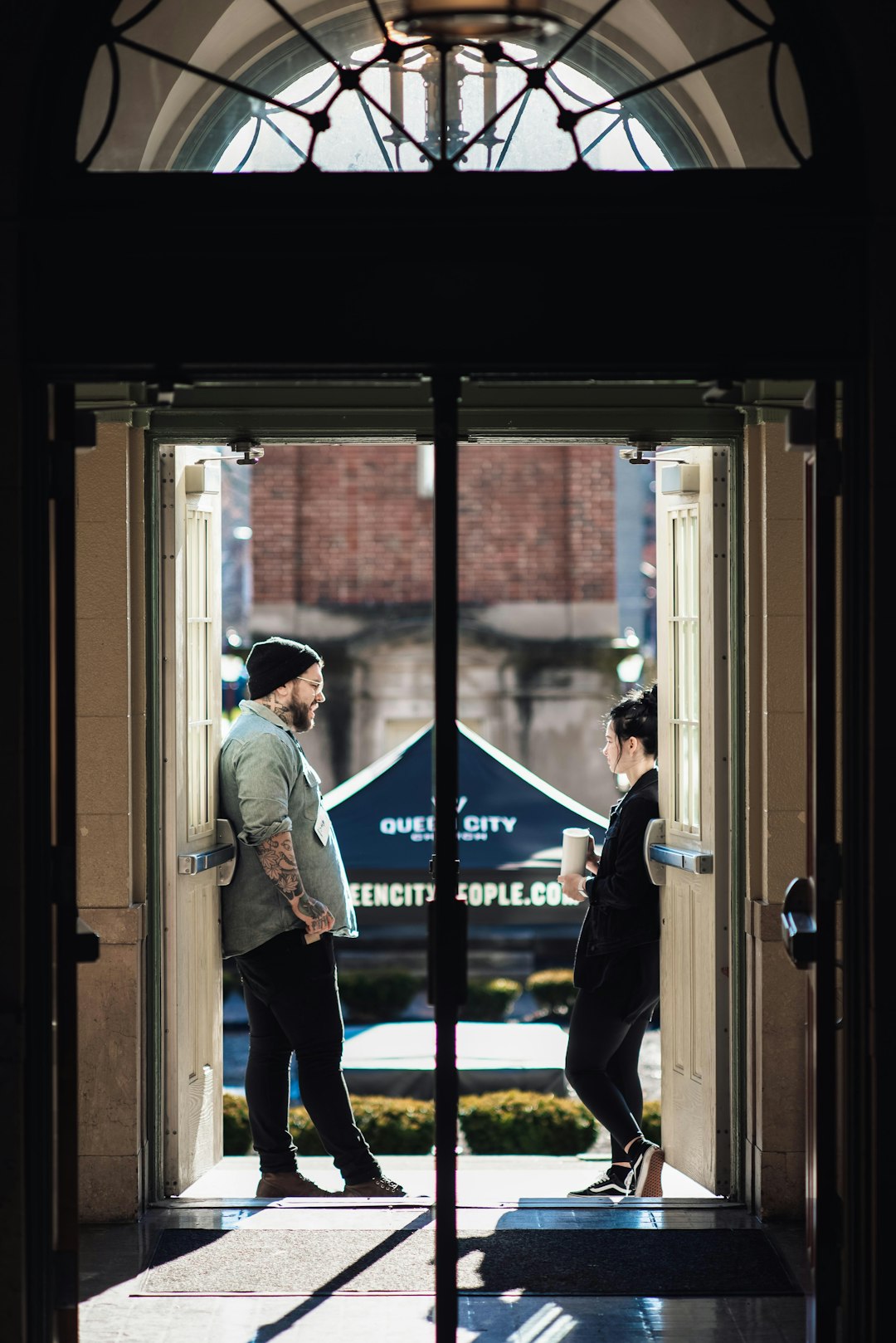man and woman talking beside the open door during daytime