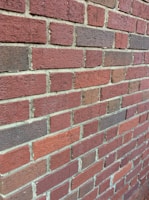 Close-up of a freshly repaired brick wall showing clean mortar lines.