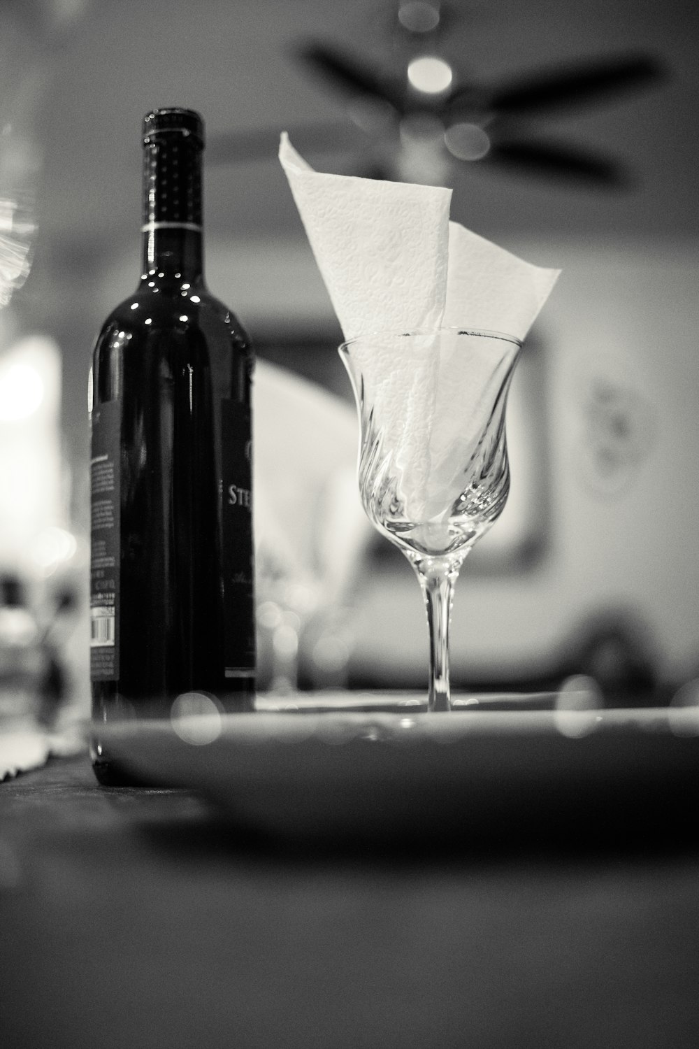 wine glass with tissue besides white bottle