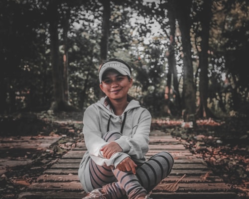 A stylish woman wearing a cozy hoodie in a casual outdoor setting.