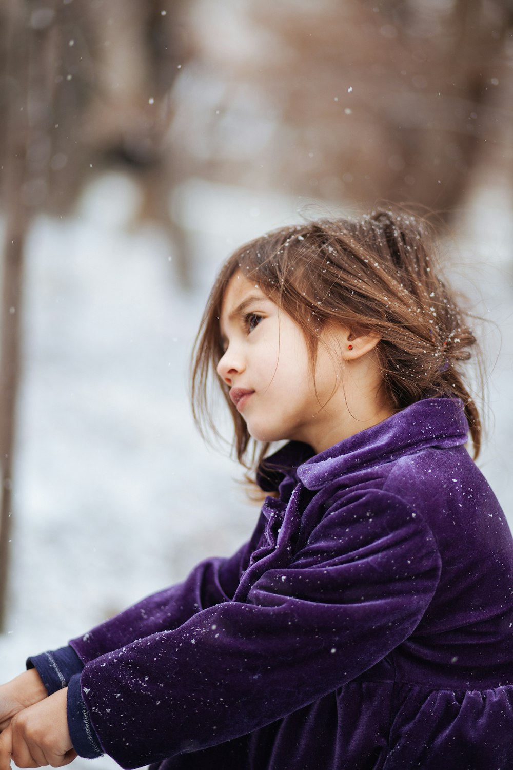 girl wearing purple jacket across blurry background