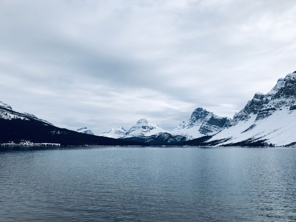 landscape photo of snow covered mountain near body of water during daytime