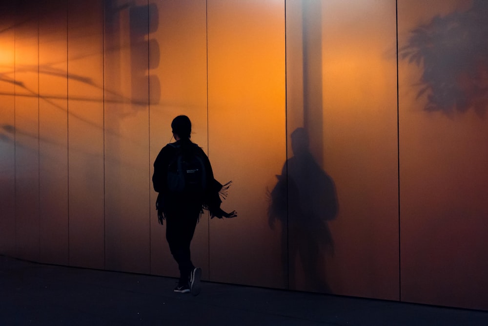 woman walking beside wall