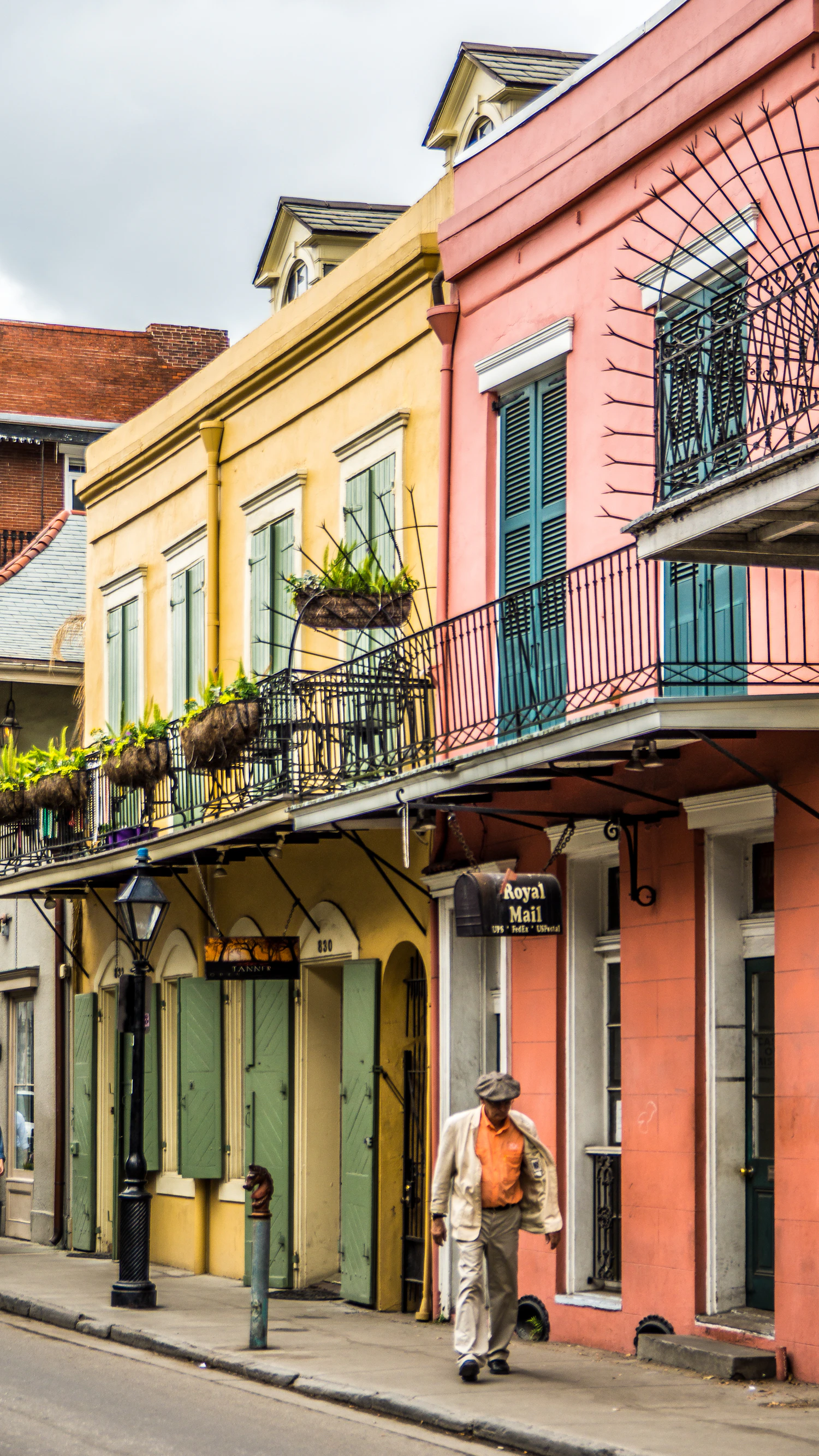Pastel New Orleans houses with green shutters and ornate balconies