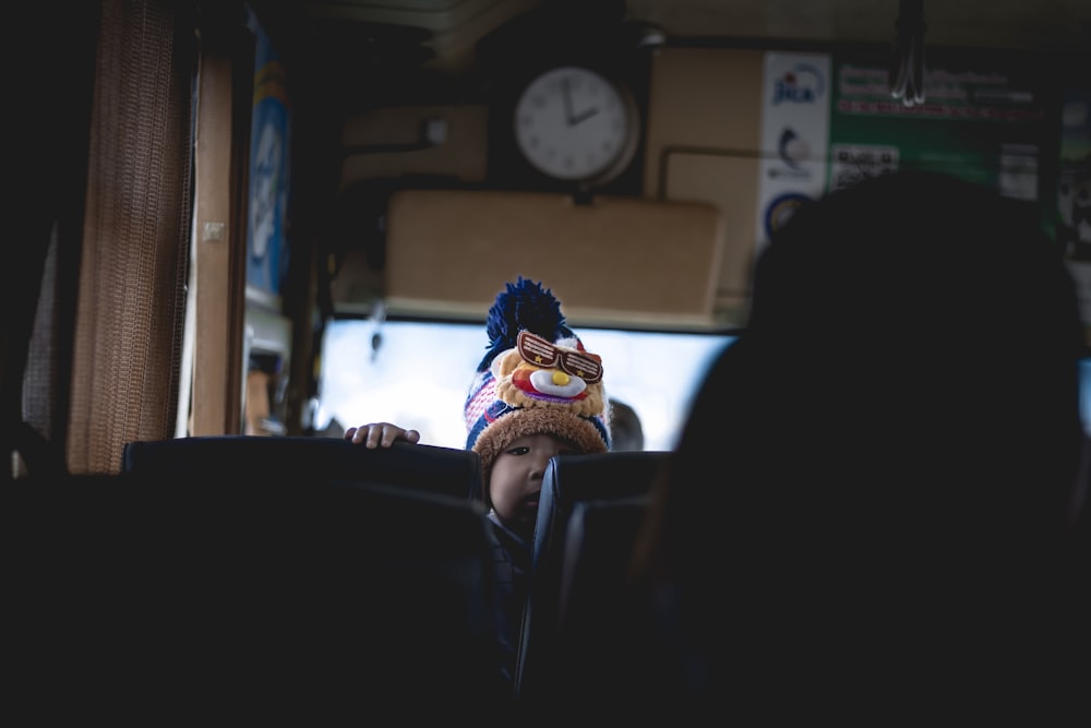 baby looking on what's behind him while sitting on bus seat