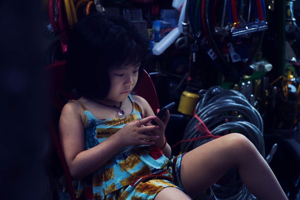 girl sits with phone in hand