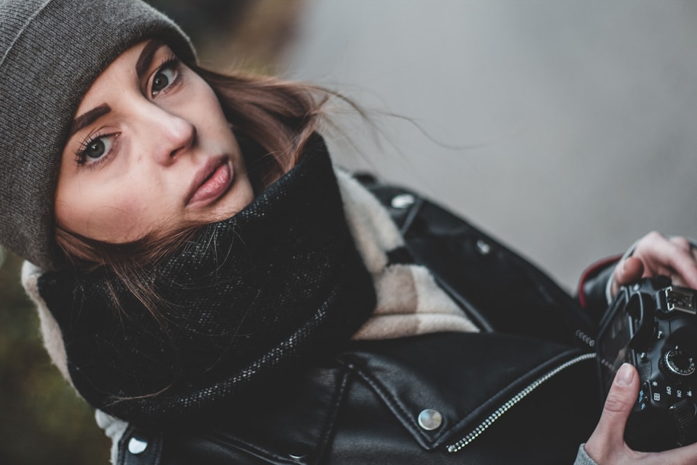 woman holding black DSLR camera