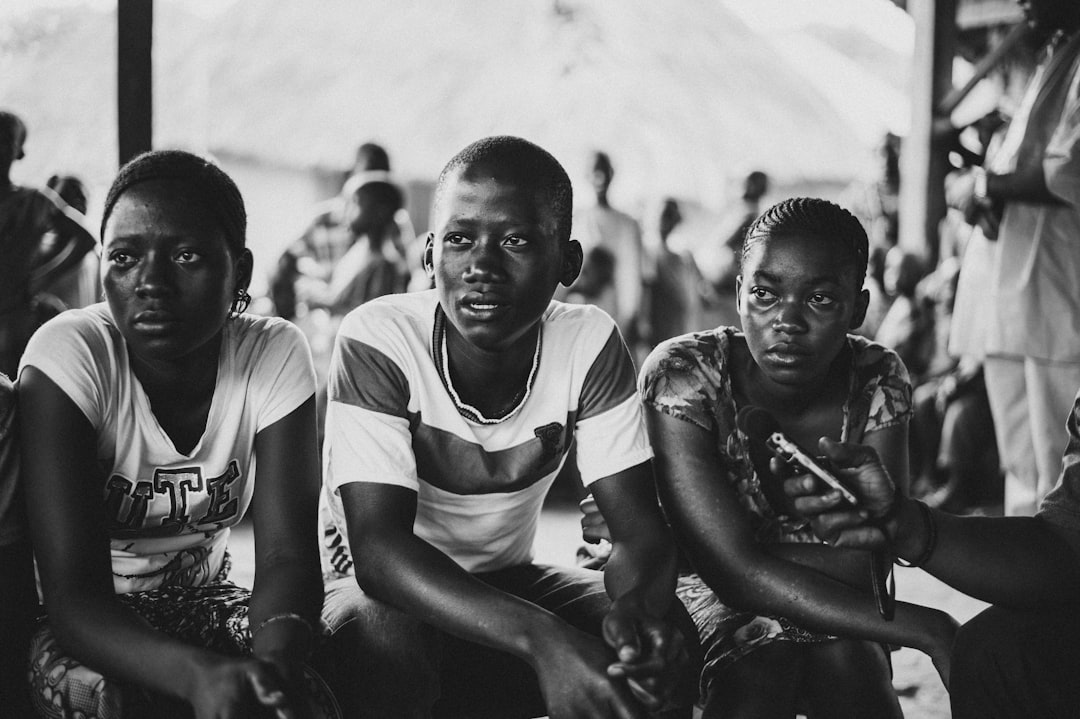 grayscale photo of three person sitting