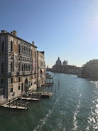 Scenic view of a group walking along the canals of Venice with historic buildings around.