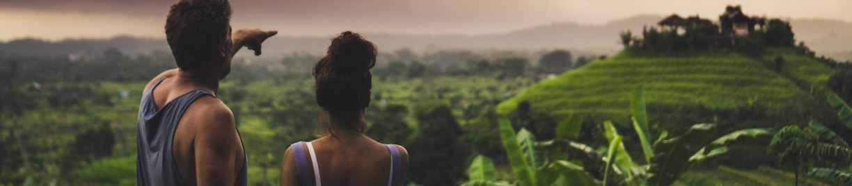 man and woman looking at hill