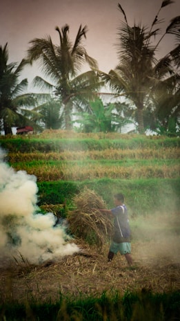 Smiling farmer holding a bundle of Bharat Rope in a lush green field.