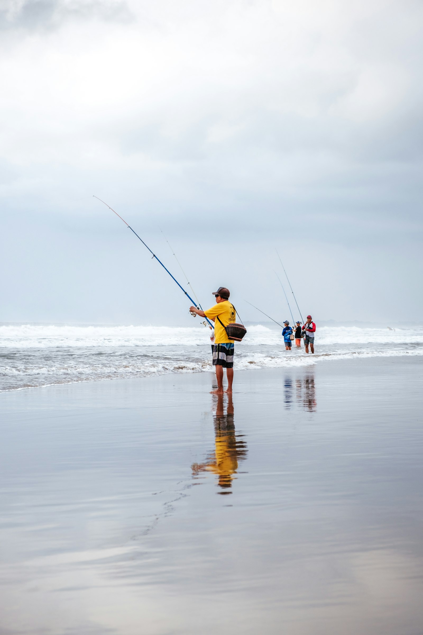 Group of anglers casting lines from the shoreline into the ocean surf