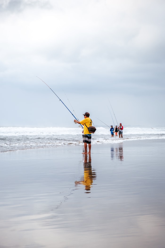 Group of anglers casting lines from the shoreline into the ocean surf