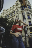 Model wearing a sleek elkora t-shirt standing against an urban backdrop.
