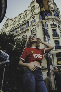 Model wearing a vibrant t-shirt from shha knit fashion, standing against a city backdrop.