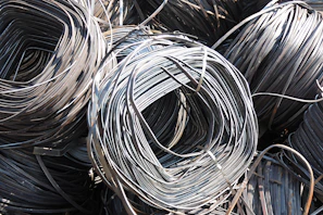 Close-up of shiny stainless steel coils stacked in a warehouse.