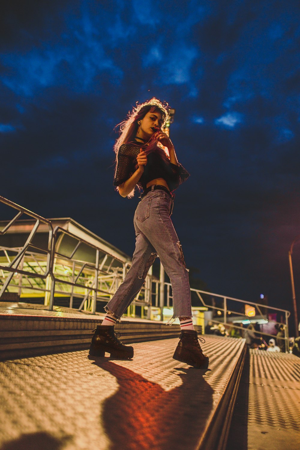 woman wearing blue ripped jeans standing on steel platform